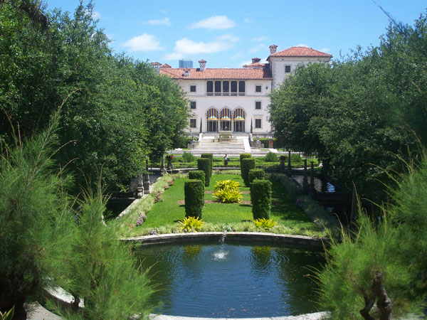 A large garden with a pond and a building.