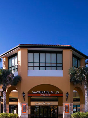 A building with a large window and palm trees.